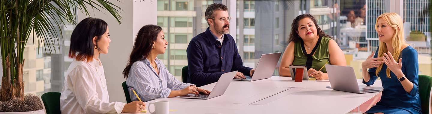 A group of five people are sitting at a table during a meeting