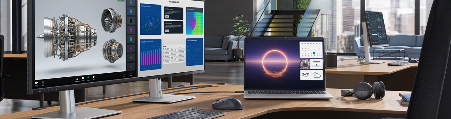 Modern workspace with multiple Dell screens displaying technical data and 3D engine model in open office environment