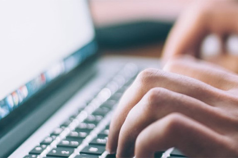 Ein Bild von Händen die auf einer Laptop Tastatur tippen symbolisieren Digitalisierung