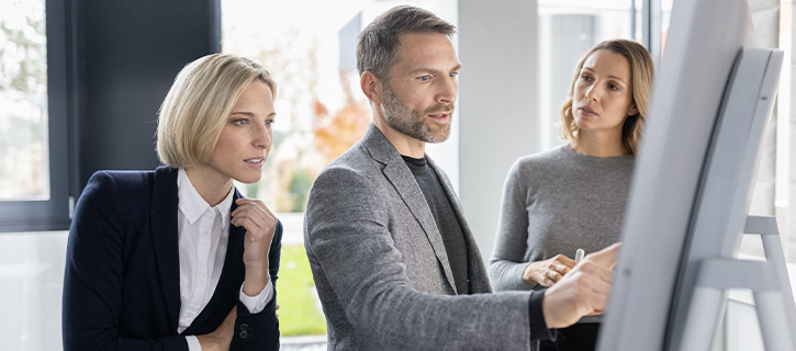 three people in front of a flipchart