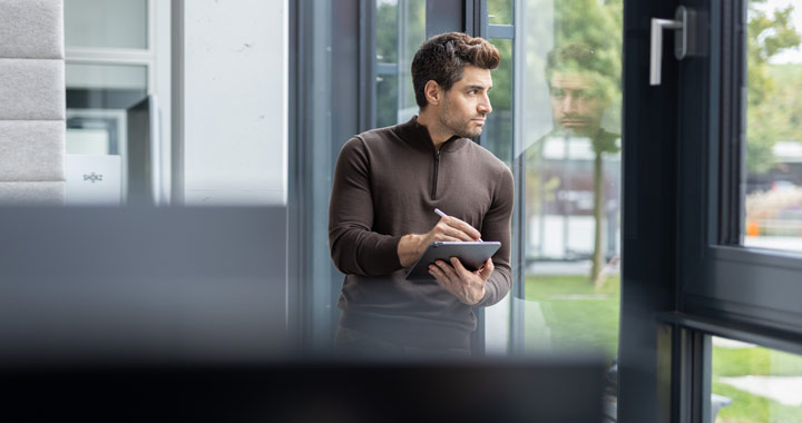 Person arbeitet im Büro mit Tablet