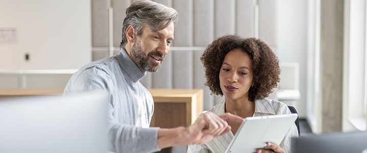 Ein Mann und eine Frau schauen auf ein Tablet