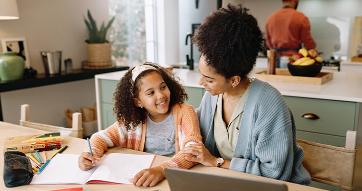 Eine Frau hilft ihrer Tochter bei den Hausaufgaben