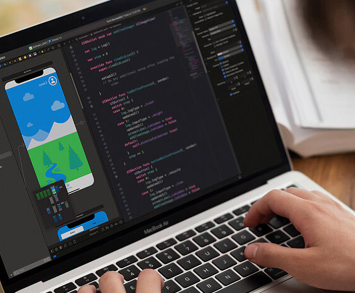 Person working on laptop with programming code and app design for mobile application in modern development environment