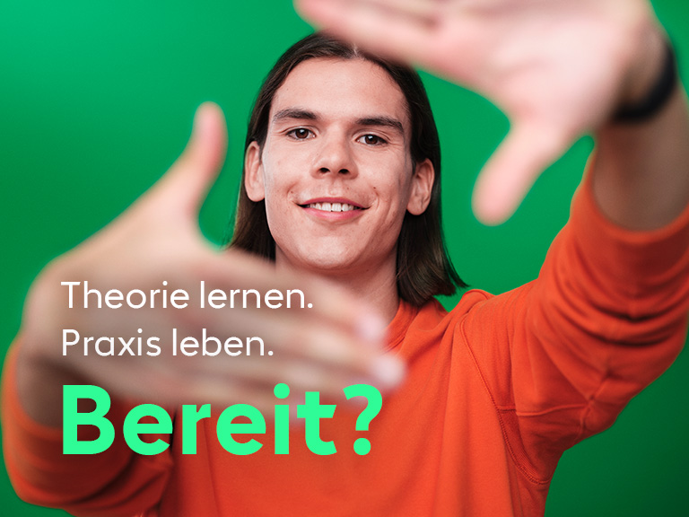 Ein junger Mann lächelt in die Kamera und streckt einladend seine Hände aus.