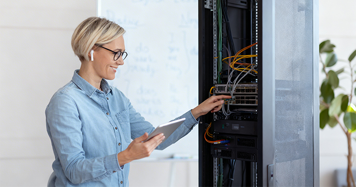Eine Frau im Lehrerzimmer kümmert sich um die Technik.