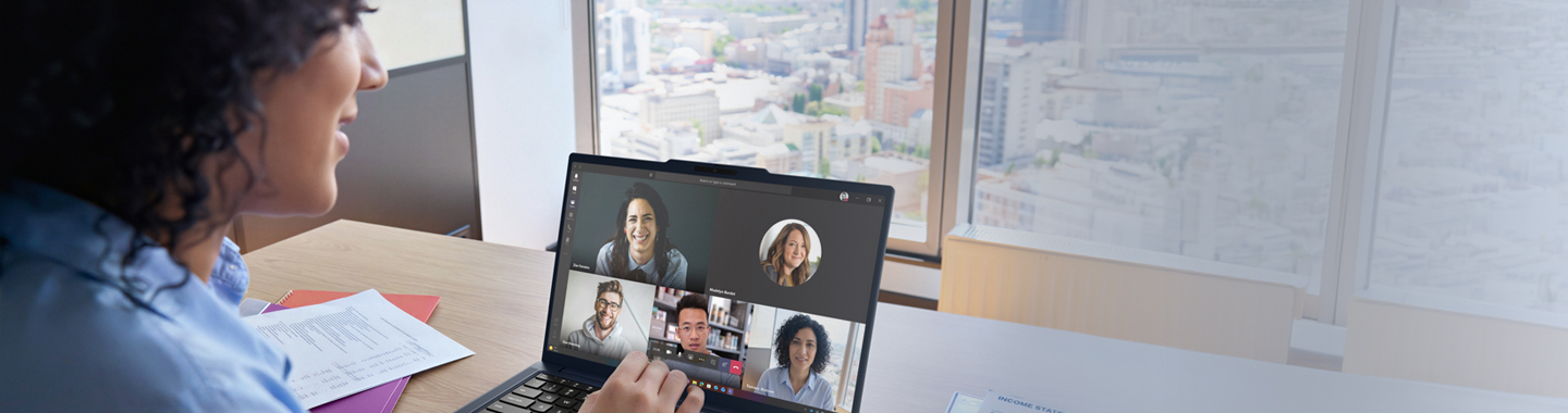 Eine Frau die am Schreitisch sitzt und über ein Notebook ein online Meeting hat.