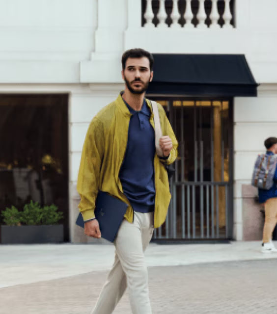 Maximise your time | Man walking through streets with laptop