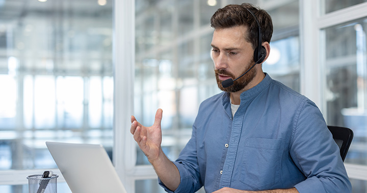 Mann mit Heaset am Laptop
