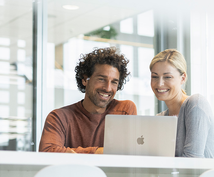 2 People talking in front of MacBook