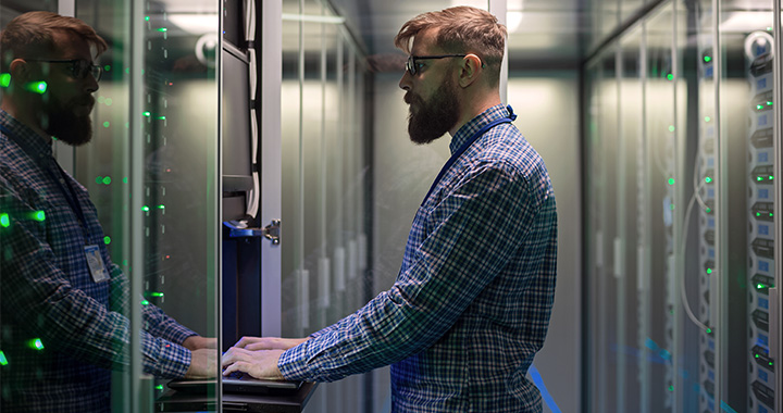 IT-Spezialist arbeitet konzentriert an Servern im Rechenzentrum zur Systemwartung
