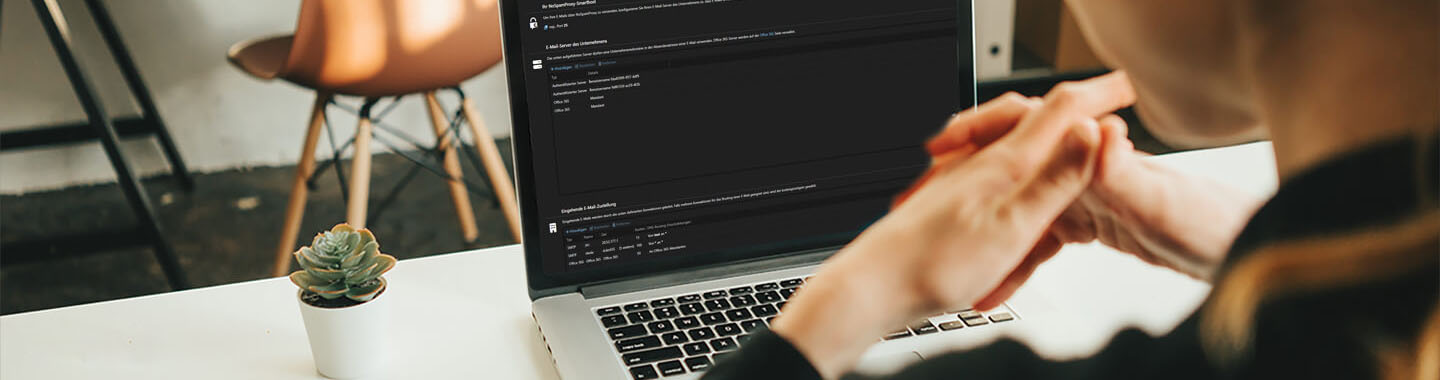 A person is sitting at a desk with an open laptop.