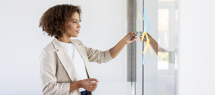 A woman is sticking the stickers in an office