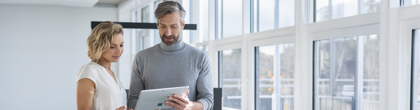 Ein Mann und eine Frau schauen auf das Tablet