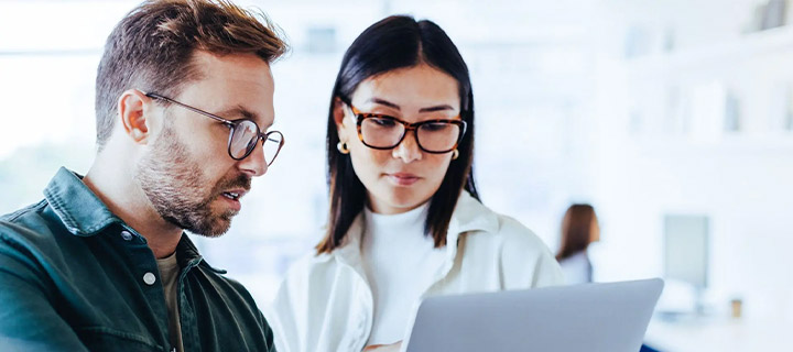 men and woman looking at a laptop