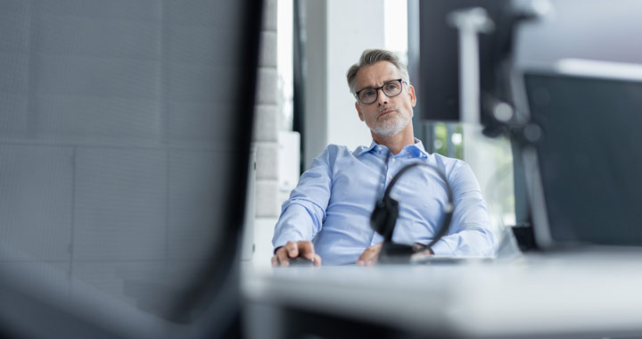 A man is sitting at a computer in the office