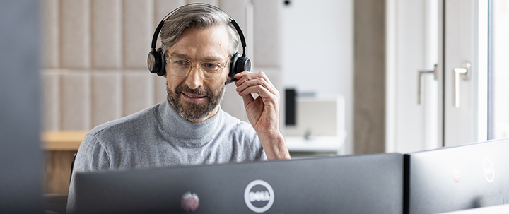 Ein Mann mit einem Headset vor einem PC