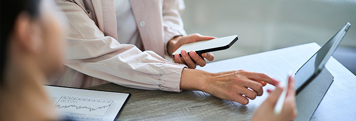 A woman is typing on a tablet