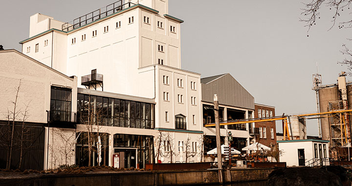 Industrial building with modern extensions by a canal in an urban environment