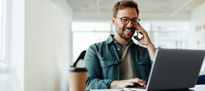Man sitting at desk looking at his laptop