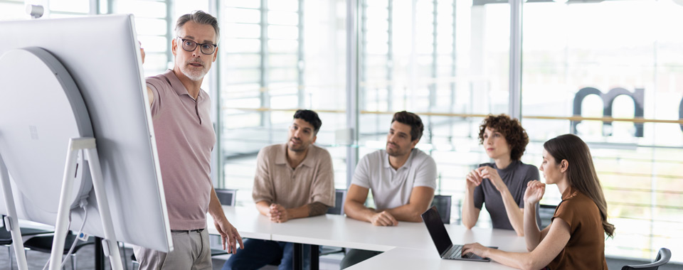 Personen im Büro vor einem Surface Hub