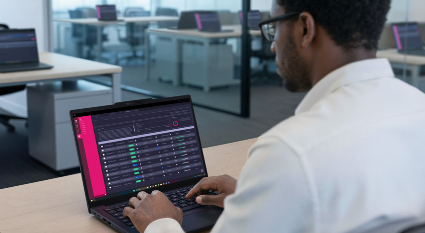 Ein Mitarbeiter sitz im Büro und arbeitet am Notebook