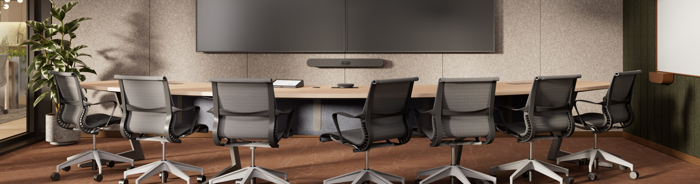 Moderner Konferenzraum mit großem Tisch, ergonomischen Stühlen und Videokonferenztechnik für Meetings