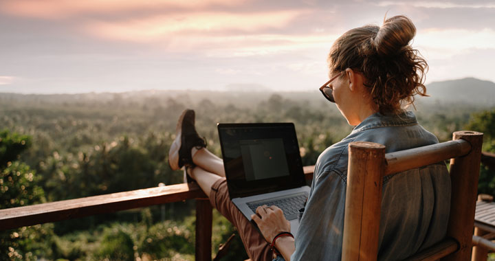 Woman using laptop at balcony