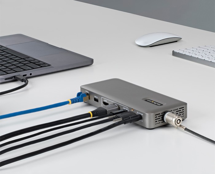StarTech Docking station with multiple connected cables extending laptop connectivity on a desk