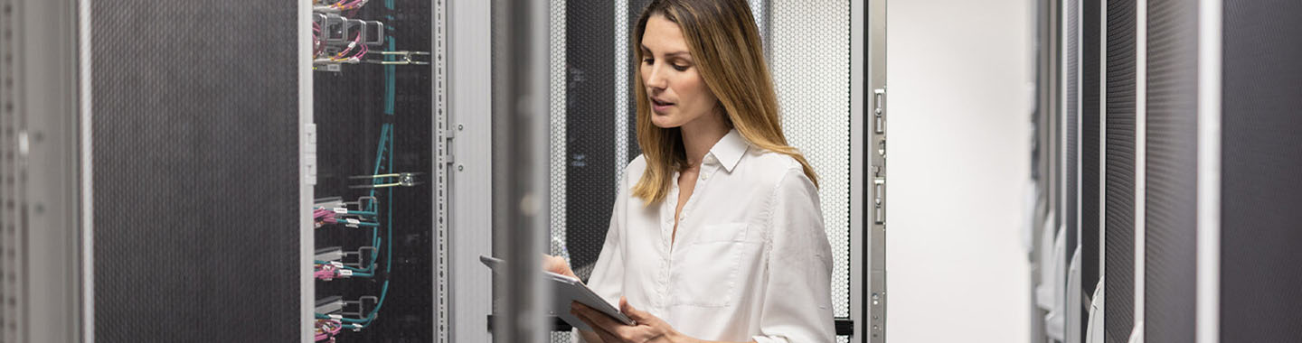 Woman inspects technical equipment in a server room for IT infrastructure and network management
