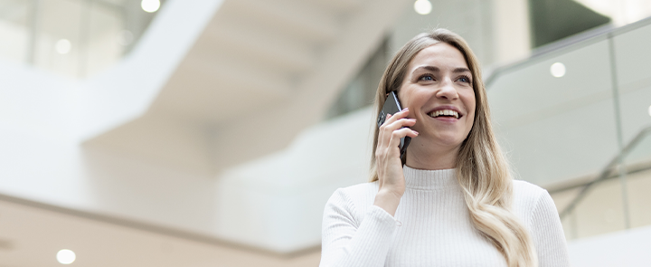 A woman sitting in an office and talking at the smartphone