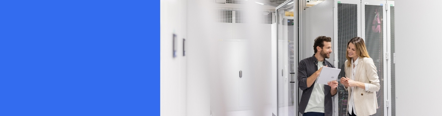 Two people in a server room discussing with a tablet 