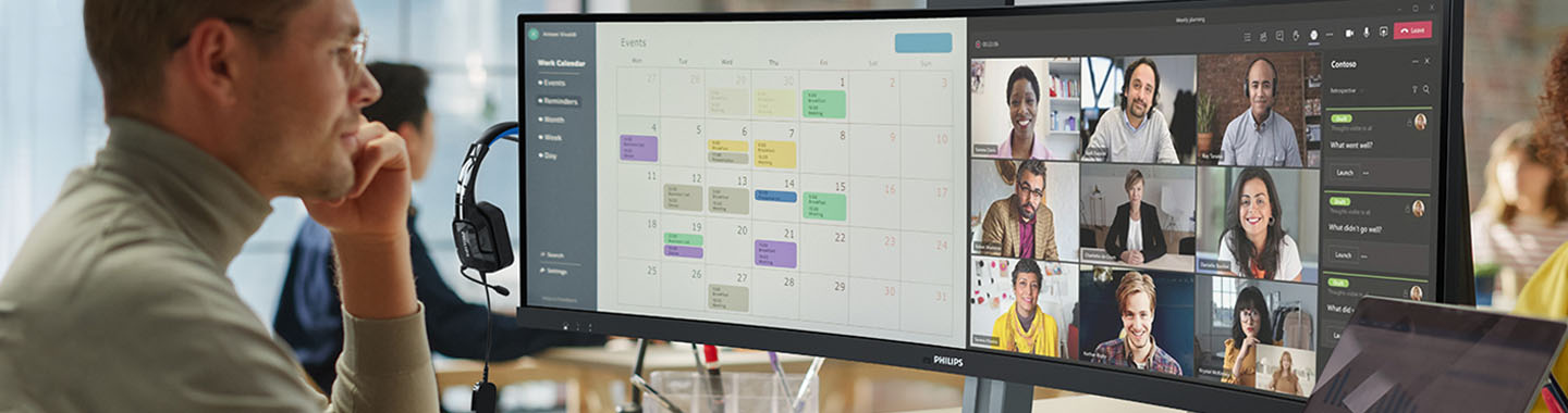 A young employee sits in front of two monitors and works.