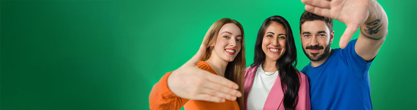 A group of three people smile at the camera and extend their hands invitingly