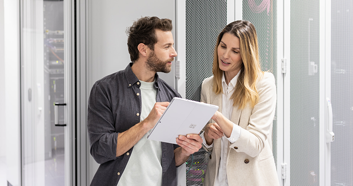 A man and a woman are discussing something on a table standing in a server room