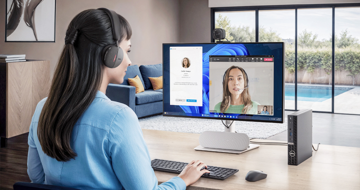 Woman on a desk with a headset in a video call.
