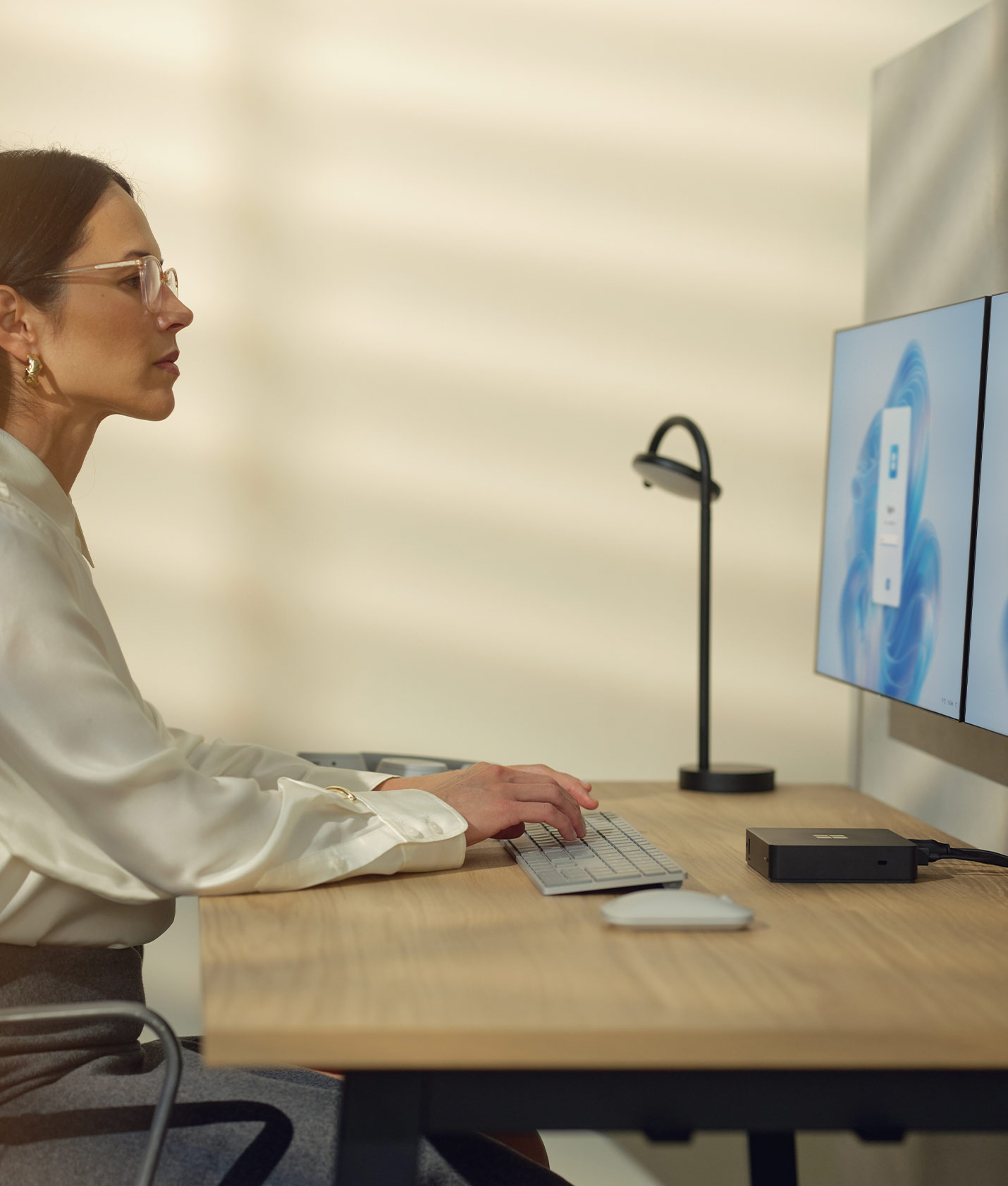 Microsoft Windows 365 Link | Woman working on two linked displays in the office.