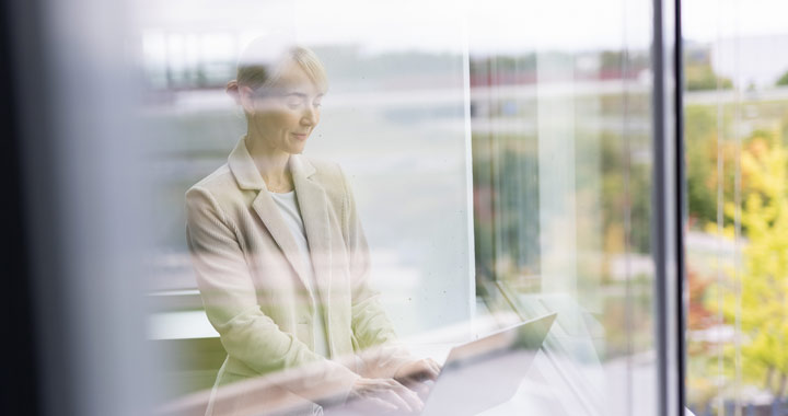 A woman is working on a computer in an office