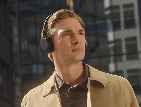 Young man wearing wireless headphones in urban setting – focus on mobile listening experience and lifestyle