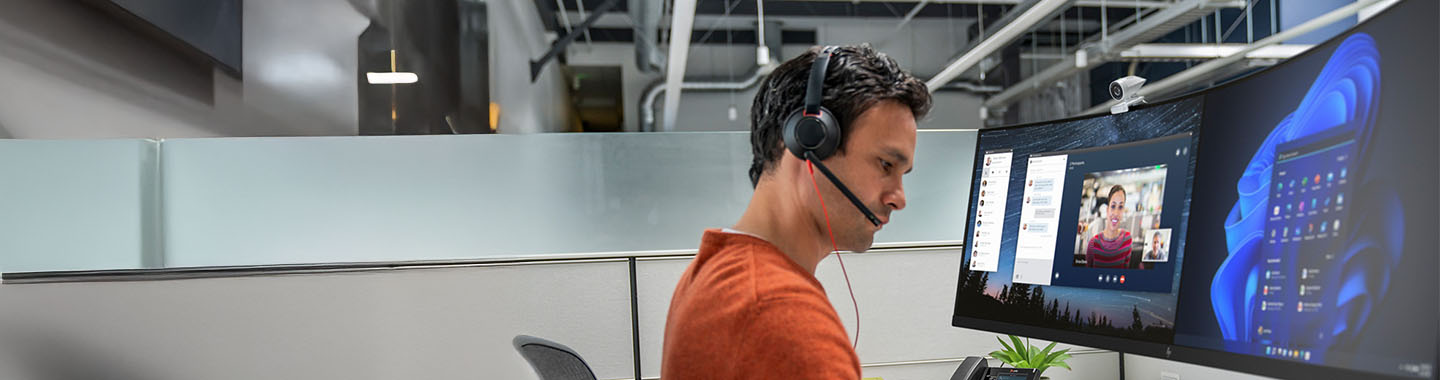 Mężczyzna w słuchawkach pracujący przy komputerze.