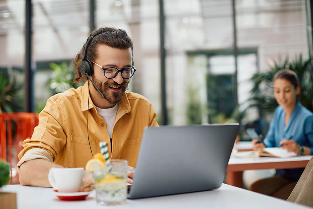 Man in café working with Yealink UH37 