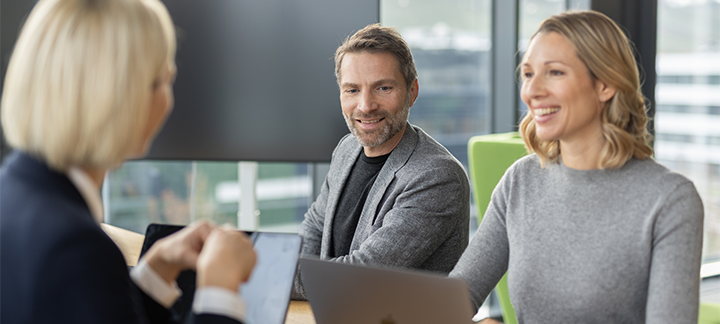 Two women and a man are talking in a meeting room 