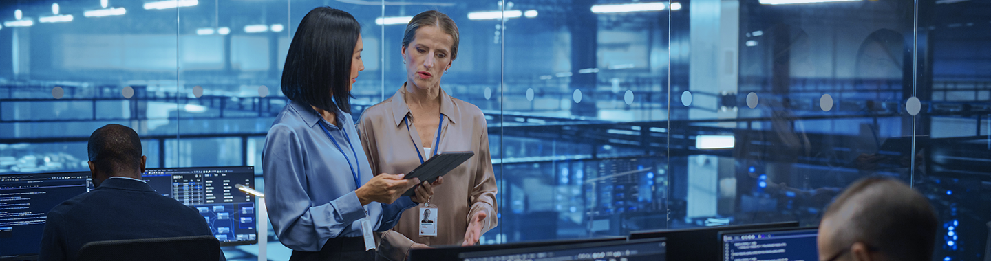 Zwei Frauen unterhalten sich in einem Serverraum.