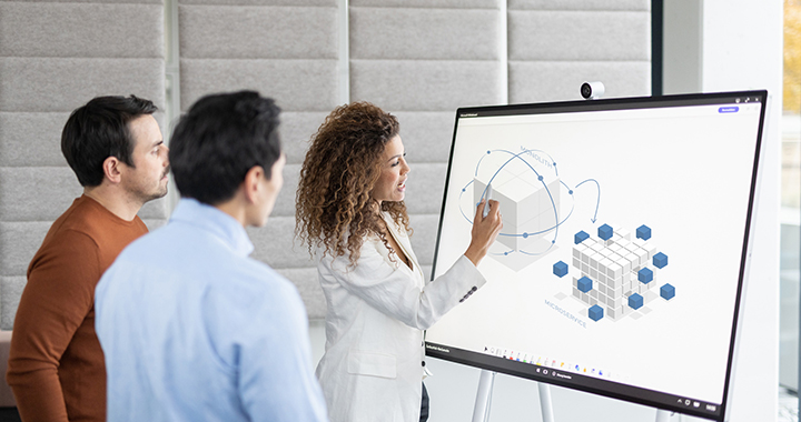Two men and a woman analyzing Kubernetes Microservices on a digital board.