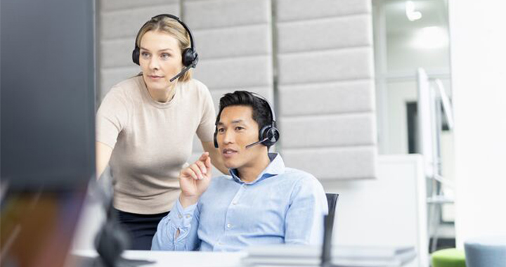 Man and Woman wearing a headset and looking at a screen