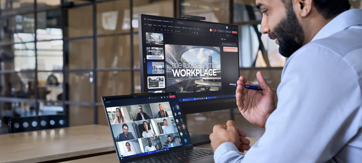 A Man in front of a Lenovo notebook and a monitor 