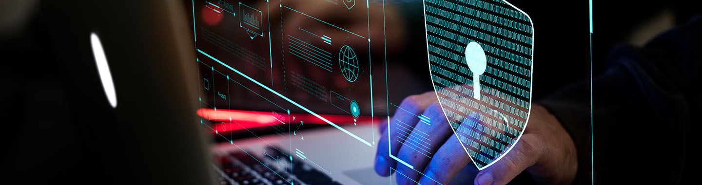 Person working on laptop with digital shield symbol representing cybersecurity and data protection