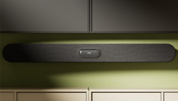 Schwarze Soundbar mit Stoffbezug montiert an grüner Wand über Sideboard für verbesserten Klang im Wohnraum