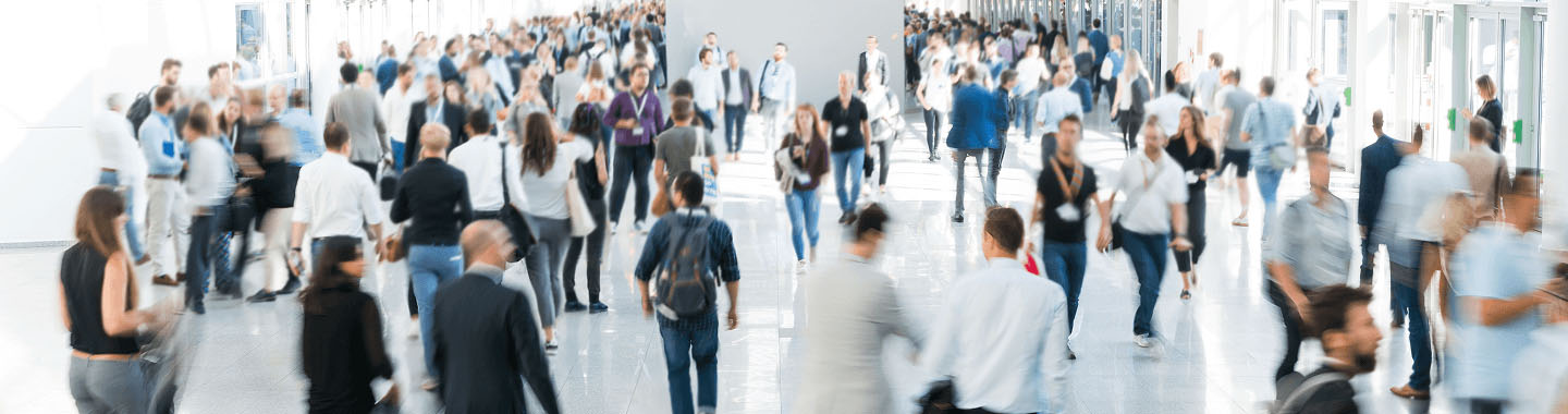 Many people walking through a big hallway