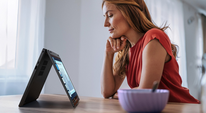 Eine Mitarbeiterin arbeitet im Home Office mit einem 2-in-1 Gerät